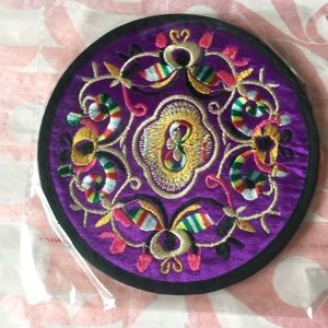 A pair of embroidered coasters